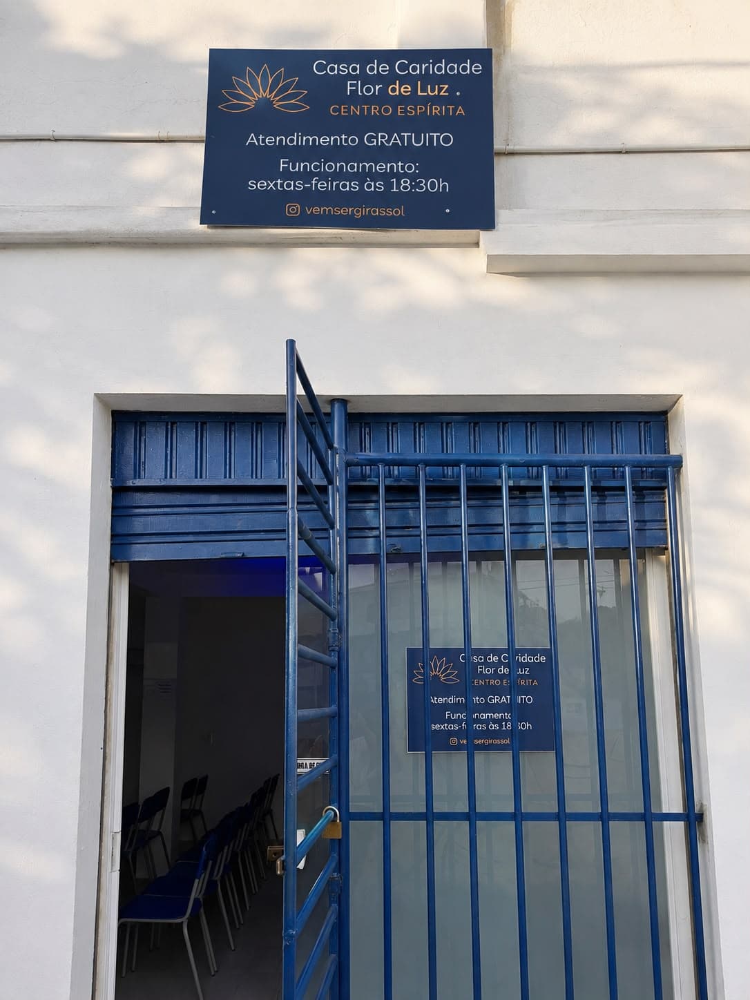 Fachada da Casa de Caridade Flor de Luz, com a placa de identificação e o portão de entrada.
